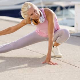Elderly sportswoman stretching legs during training